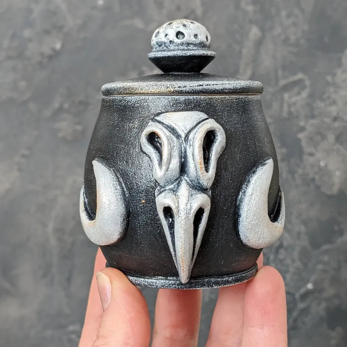 crow skull wooden pot with lid in hand