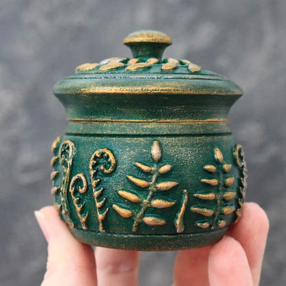 emerald magic small wooden pot with lid in hands