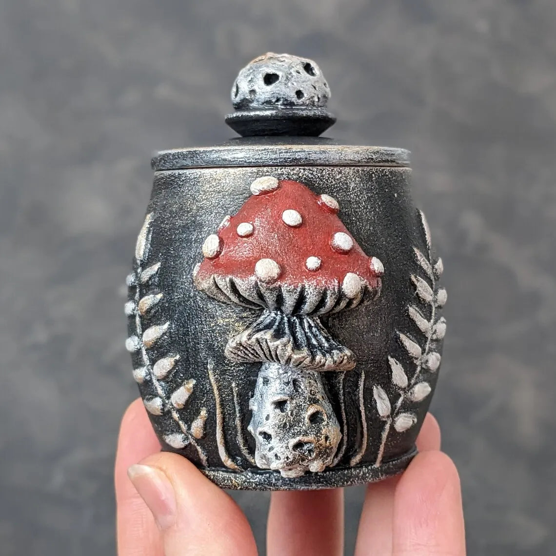 fly agaric mushroom wooden pot with lid in hand red mushroom