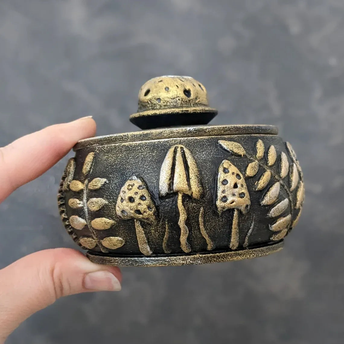 forest glade golden wooden pot with lid held by hand