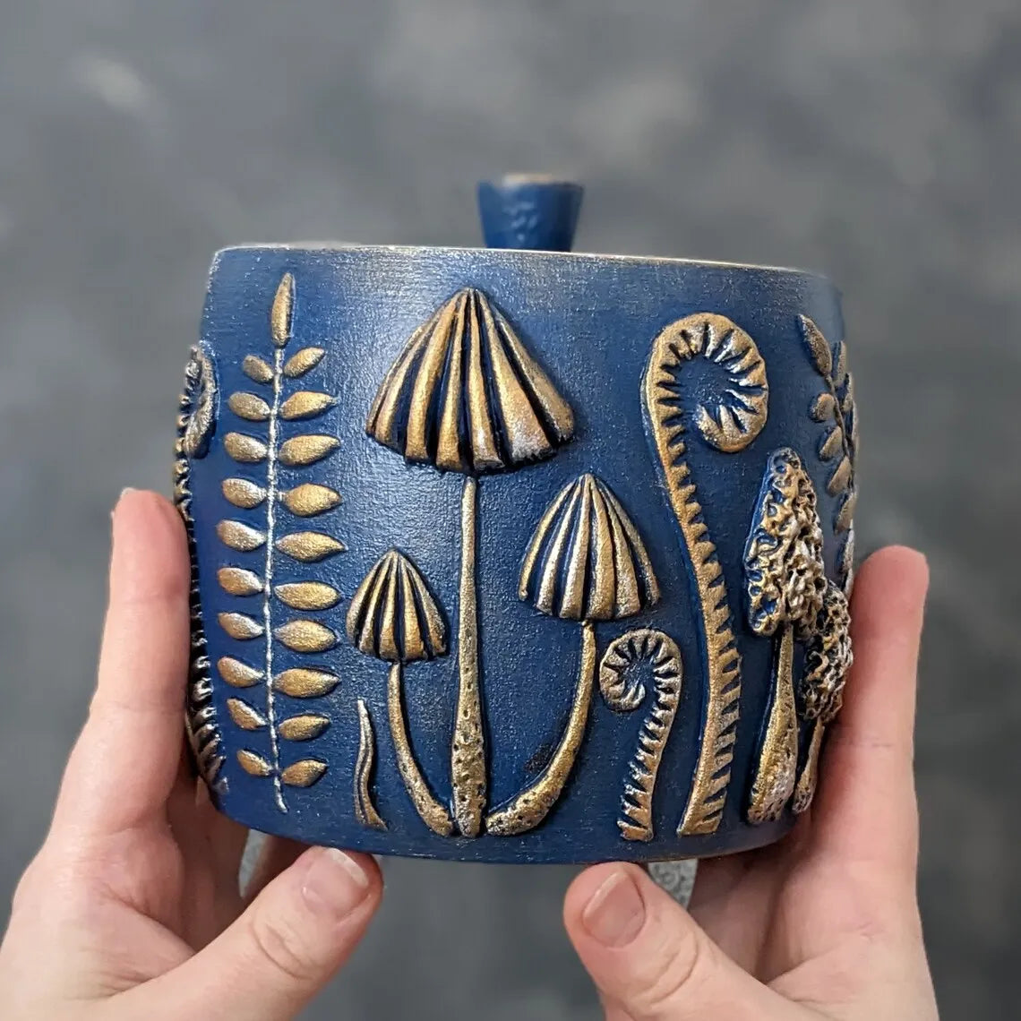 forest herbs and mushrooms blue wooden pot with lid in hands