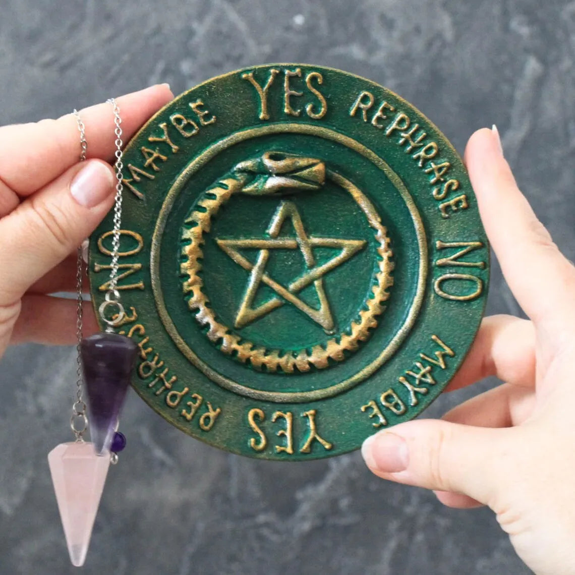 ouroboros pentagram pendulum board in hands with pendulum