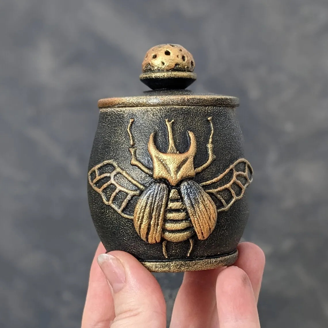 witch beetle wooden pot with lid in hand