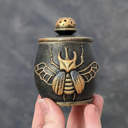 witch beetle wooden pot with lid in hand