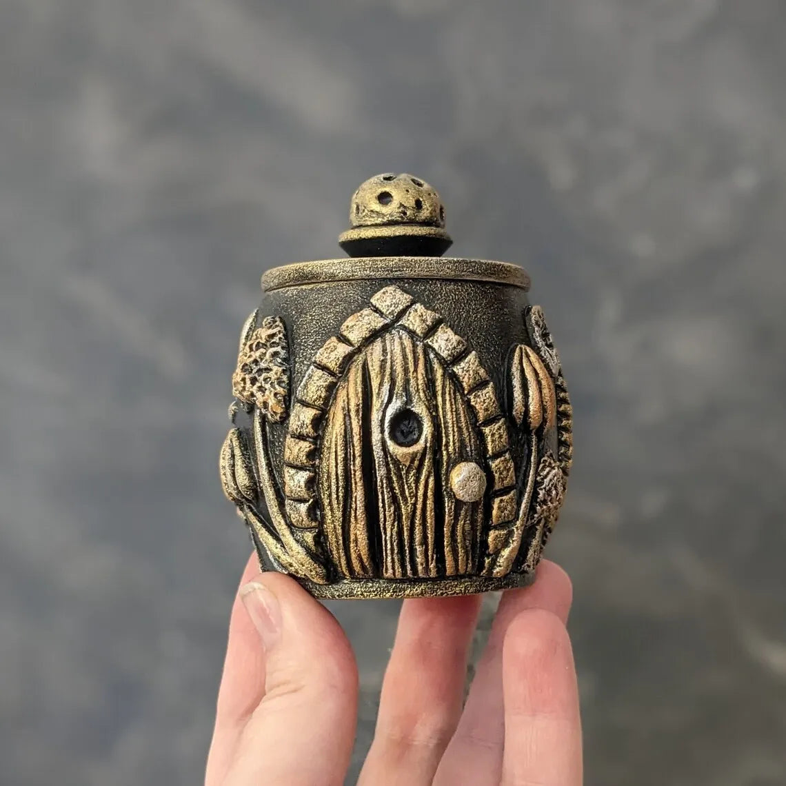 witch door golden wooden pot with lid in hand