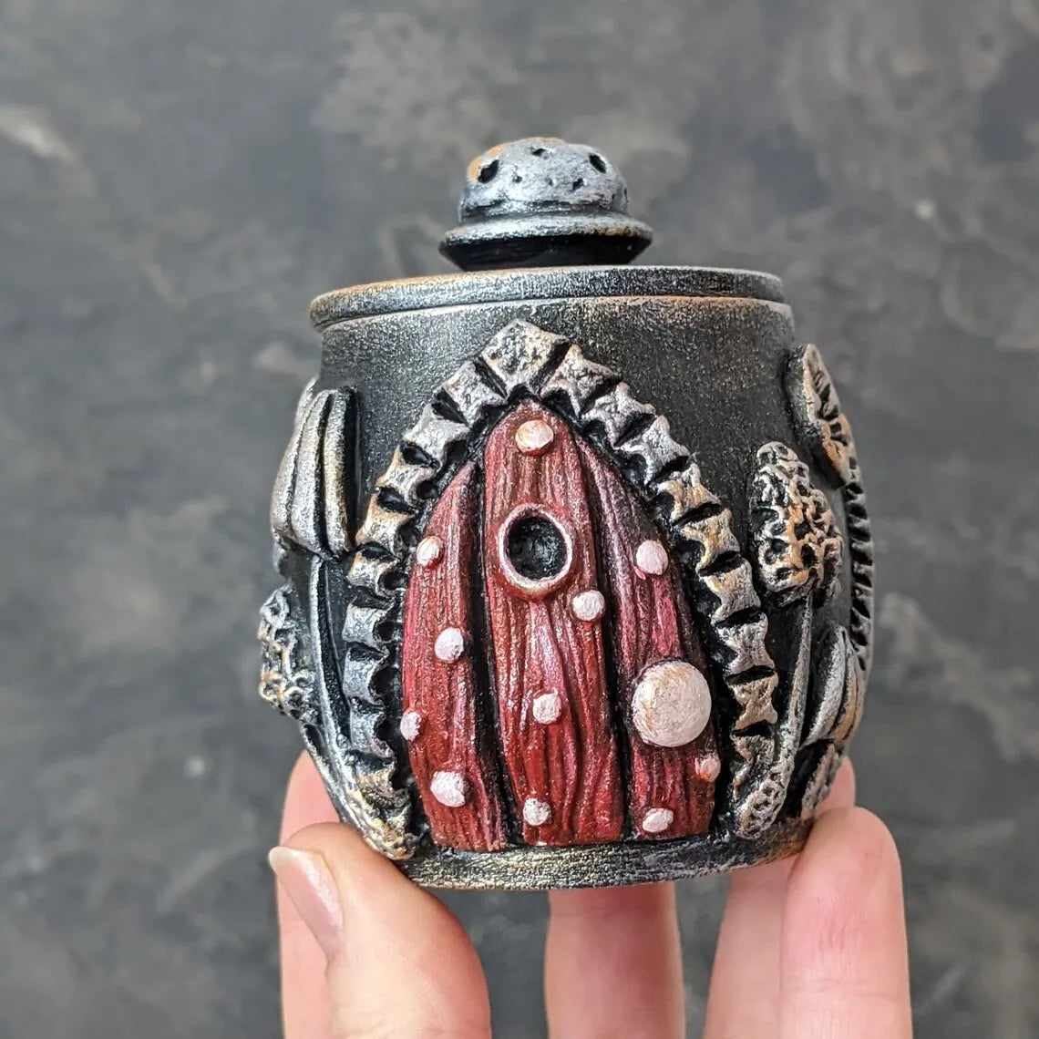 witch door wooden pot with lid in hand